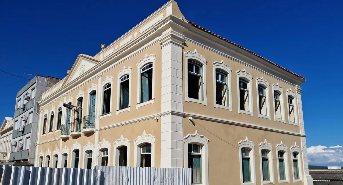 O mesmo prédio histórico depois do restauro, com fachada recuperada, pintura nova e ornamentos em destaque